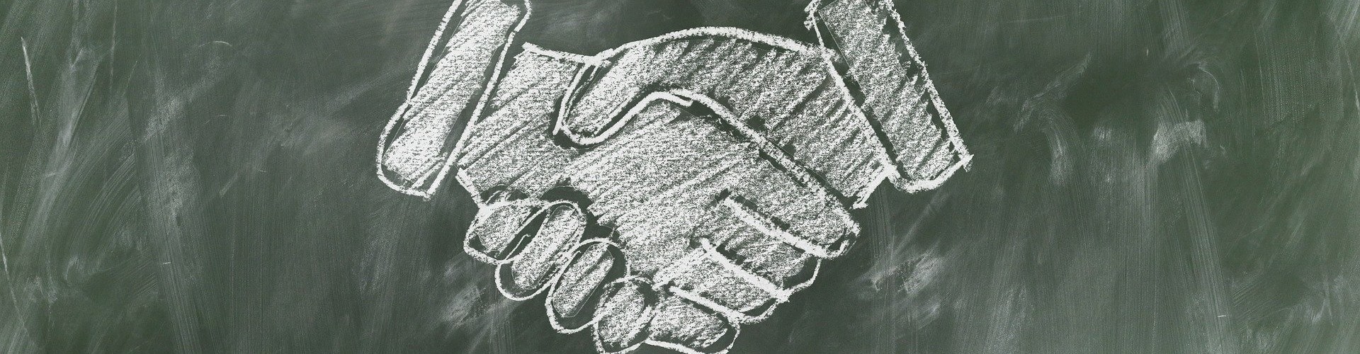 Shaking hands drawn on blackboard in chalk
