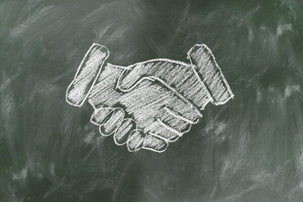 Shaking hands drawn on blackboard in chalk