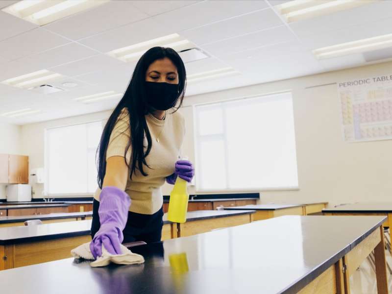 Woman cleaning tables at a school