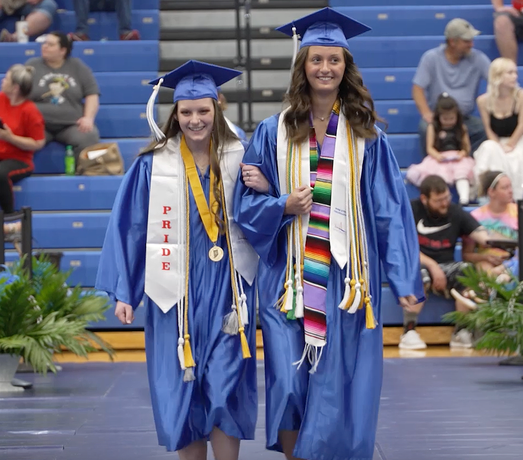 Two seniors walking into the graduation ceremony